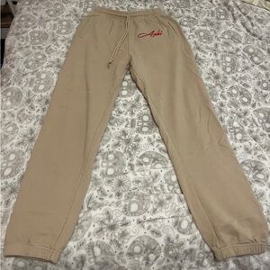 Beige Alpha Phi drawstring sweatpants w/ “Aphi” in red cursive writing & pockets